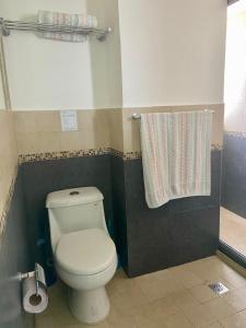 a bathroom with a toilet and a shower curtain at Cozy and Modern in Cancún +16 photos
