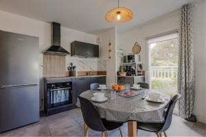 eine Küche und ein Esszimmer mit einem Tisch und Stühlen in der Unterkunft Appartement T2 idéal 2 personnes-150 m de la plage in Biscarrosse