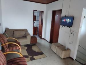 a living room with a couch and a tv at Hostel Palhoça in Palhoça