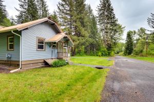 a small blue house with a yard next to a road at Mt Rainier Retreat 7 Mi to Park Entrance! in Ashford