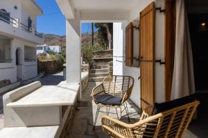 a balcony with two chairs and a table on a building at Κυκλαδίτικο Studio in Kionia