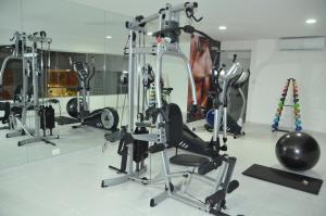 a gym with several tread machines in a room at Arituba Park Hotel in Natal