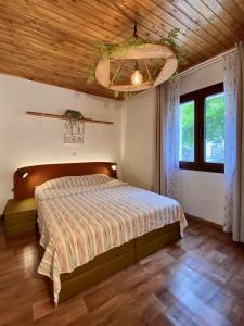 a bedroom with a bed and a wooden ceiling at Lakis' Wellhouse in Ano Poroia