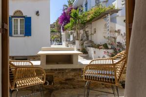 a patio with two chairs and a table on a building at Κυκλαδίτικο Studio in Kionia