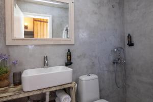 a bathroom with a sink and a toilet and a mirror at Κυκλαδίτικο Studio in Kionia