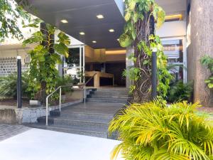 a lobby of a building with stairs and plants at Arituba Park Hotel in Natal