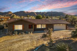 una casa con una montaña al fondo en The Latham Abode - Spa - Fire-pit - Game Room - NEW, en Joshua Tree