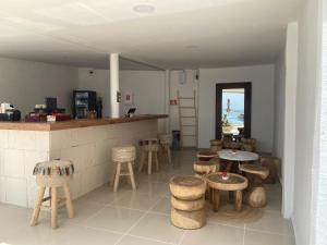 a restaurant with tables and stools in a room at Cozy and Modern in Cancún