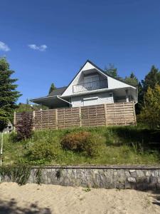 a house on top of a hill with a fence at Dom całoroczny, Krzeszna in Krzeszna