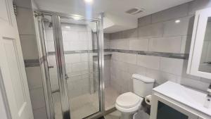 a bathroom with a shower and a toilet and a sink at 1-bedroom One Woodbrook Place Apartment! in Port-of-Spain