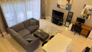 a living room with a couch and a tv at 1-bedroom One Woodbrook Place Apartment! in Port-of-Spain