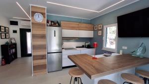 a kitchen with a refrigerator and a table with chairs at House Holiday Lodge in Žirje