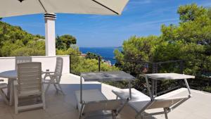 a patio with a table and chairs and a view of the ocean at House Holiday Lodge in Žirje