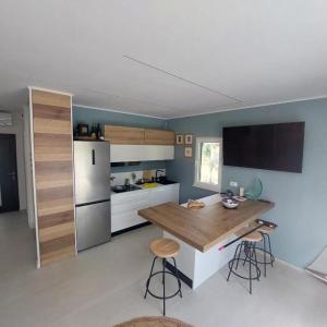 a kitchen with a counter and a kitchen island with stools at House Holiday Lodge in Žirje +19 photos