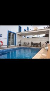 a swimming pool with tables and chairs next to a building at MERAKI Villa in Paralimni +12 photos