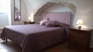 a bedroom with a bed with a purple bedspread at Dimora del Sole in Putignano +36 photos