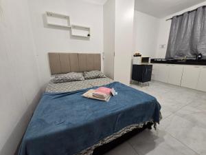 a bedroom with a bed with a blue blanket at Flat completo a 5 minutos apé de mercado, farmácia in Aparecida de Goiania