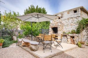a table and chairs with an umbrella in a garden at House Punat Residence in Punat