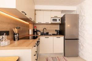 a kitchen with white cabinets and a stainless steel refrigerator at House Punat Residence in Punat