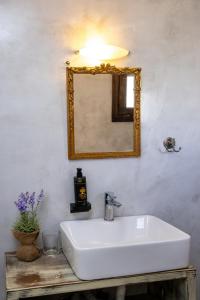 a bathroom with a white sink and a mirror at Κυκλαδίτικο studio στα Κιόνια in Kionia