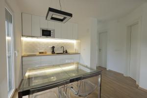a kitchen with a glass table and a sink at Danka Pool House in Usije +13 photos