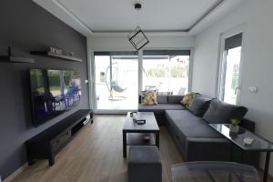 a living room with a couch and a tv at Danka Pool House in Usije