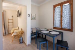 a dining room with a blue table and a window at Κυκλαδίτικο studio στα Κιόνια in Kionia