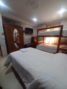 a bedroom with two bunk beds and a mirror at Quinta Alpaca - Departamento 1er piso in Arequipa
