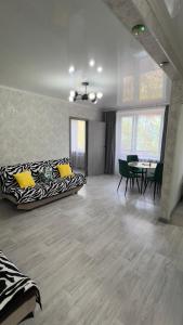 a living room with a zebra couch and a table at Двухкомнатная квартира в центре города Сейфуллина 33 in Balqash