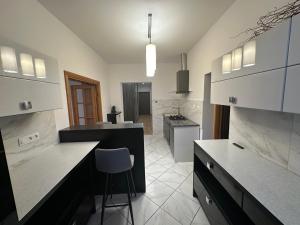 a kitchen with a counter and a chair in it at Apartament blisko Krzywej Wieży Dostęp za pomocą kodu in Ząbkowice Śląskie
