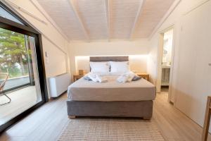 une chambre avec un lit et une grande fenêtre dans l'établissement Villa Episkopos Seaside, à Nikiana