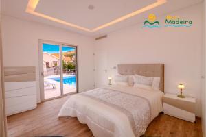 a bedroom with a bed and a swimming pool at OurMadeira - CalhetaScape, informal in Calheta +20 photos