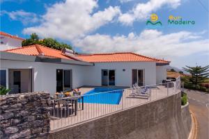 a villa with a swimming pool and a house at OurMadeira - CalhetaScape, informal in Calheta