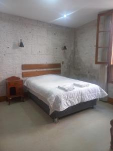 a bedroom with a large bed and a night stand at Quinta Alpaca - Departamento 1er piso in Arequipa