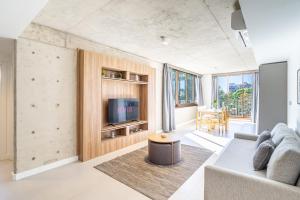 a living room with a couch and a tv at Deluxe Recoleta Apartments - By Magno in Buenos Aires