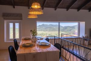 a dining room with a table with chairs and a large window at Amalia Casa Lefkada in Pigadhisánoi