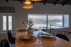 a dining room table with glasses and plates on it at Amalia Casa Lefkada in Pigadhisánoi
