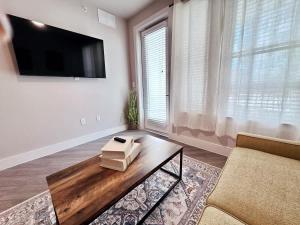 a living room with a coffee table and a flat screen tv at Cozy 1BR Near Domain Pool &Gym in Austin