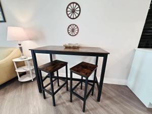a black table with two chairs and a clock on the wall at Cozy 1BR Near Domain Pool &Gym in Austin