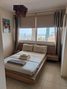 una cama en una habitación con una ventana grande en Superior 1 bed apartment in Oroklini with Communal Pool, en Oroklini