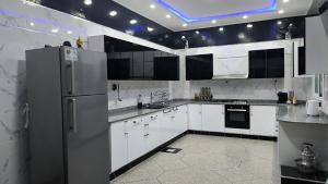 a kitchen with white cabinets and a refrigerator at Home Amazigh Serenity in Tinerhir