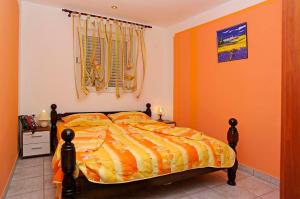 a bedroom with a bed with orange walls and a window at Foissner Apartments in Zavalatica