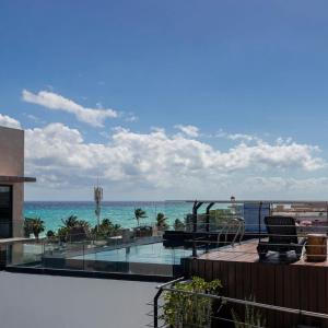 Una vista del océano desde el balcón de un resort. en Sole Suites, en Playa del Carmen