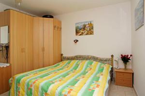 a bed with a colorful comforter in a bedroom at Foissner Apartments in Zavalatica