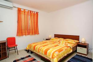 a bedroom with a bed and a red chair at Foissner Apartments in Zavalatica