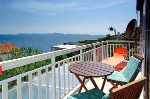 a table and chairs on a balcony with the ocean at Foissner Apartments in Zavalatica