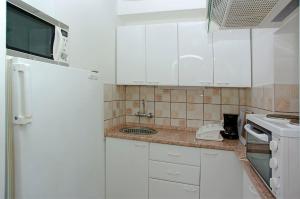 a kitchen with white cabinets and a white refrigerator at Foissner Apartments in Zavalatica