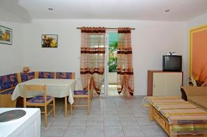 a living room with a table and a tv at Foissner Apartments in Zavalatica