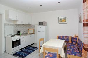 a kitchen with a table and a table and a chair at Foissner Apartments in Zavalatica