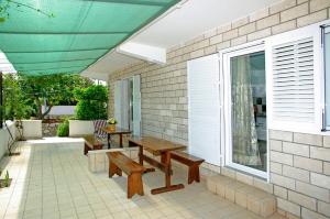 a patio with benches and a table and a window at Foissner Apartments in Zavalatica